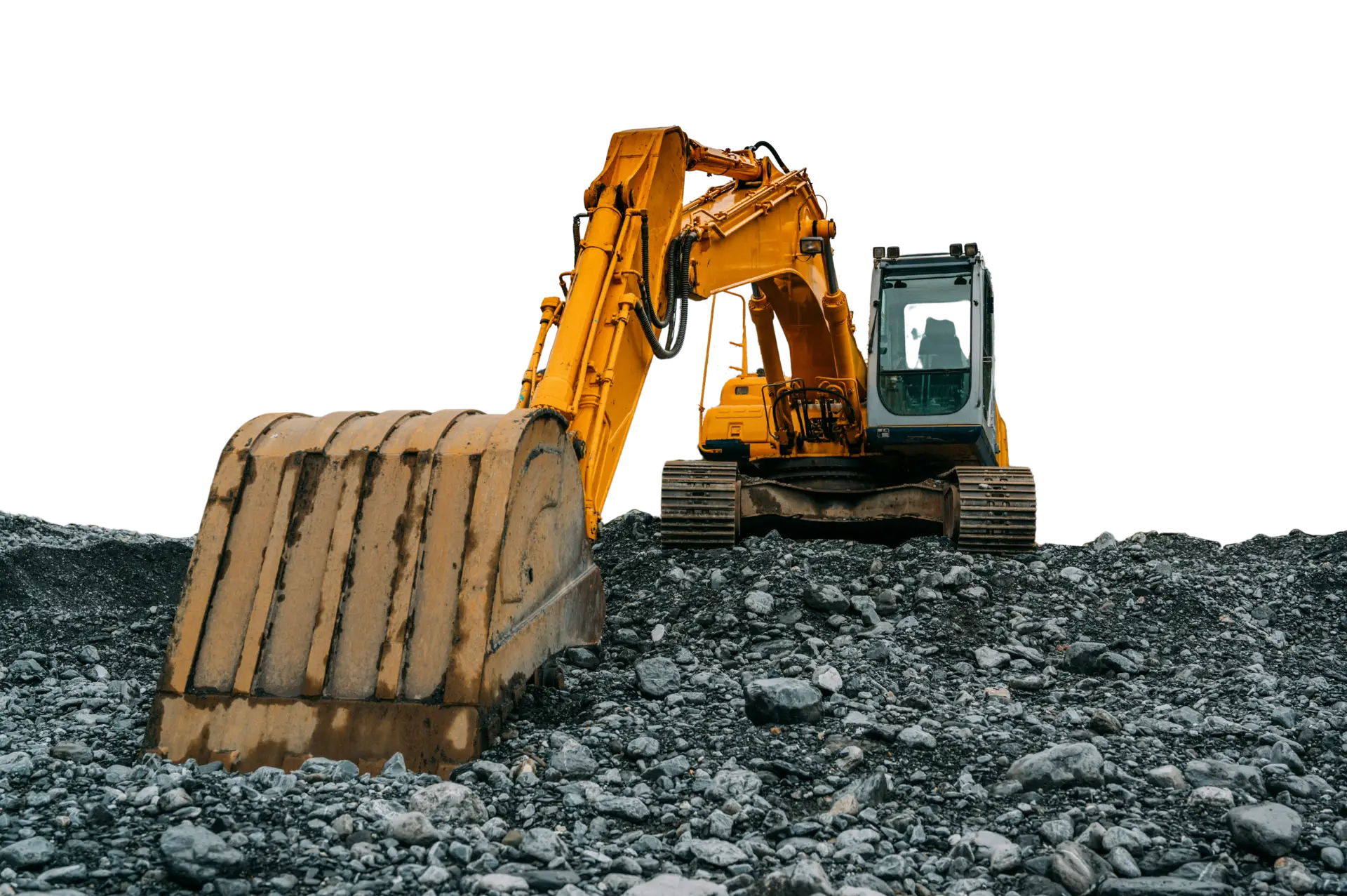 An excavator with its bucket in front view parked in a gravel site.