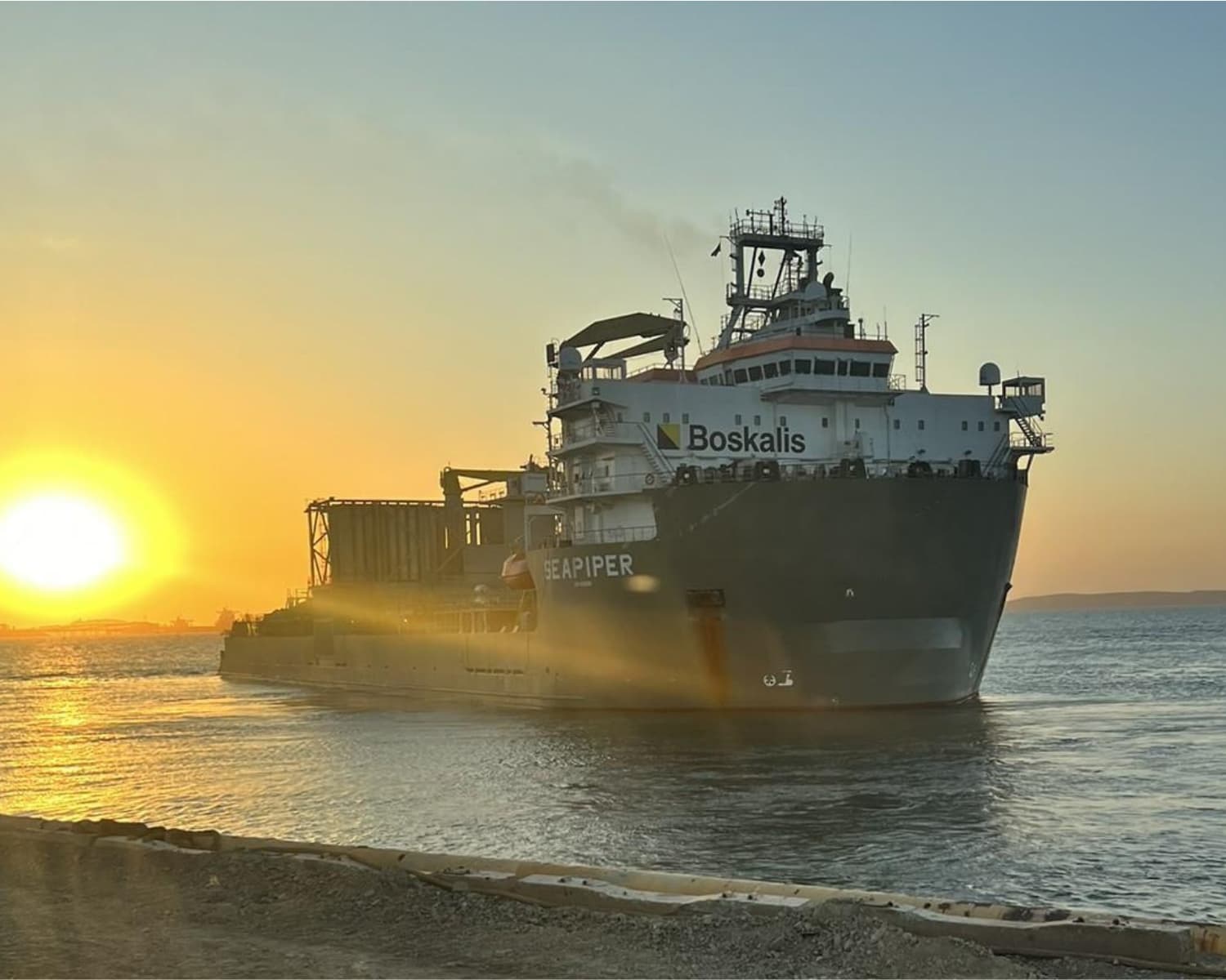 A sea piper ship in the nearby shore with a sunset background.